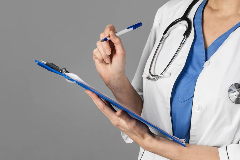 Plano fechado de uma médica com estetoscópio no pescoço, segurando uma prancheta e uma caneta, enquanto organiza informações sobre a tabela de reajuste de plano de saúde por faixa etária.